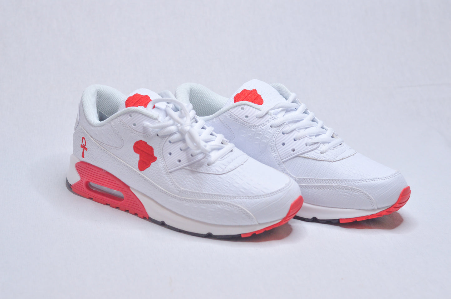 Side profile of Marcus Garvey UNIA Star Sneakers featuring white leather upper and red outsole.