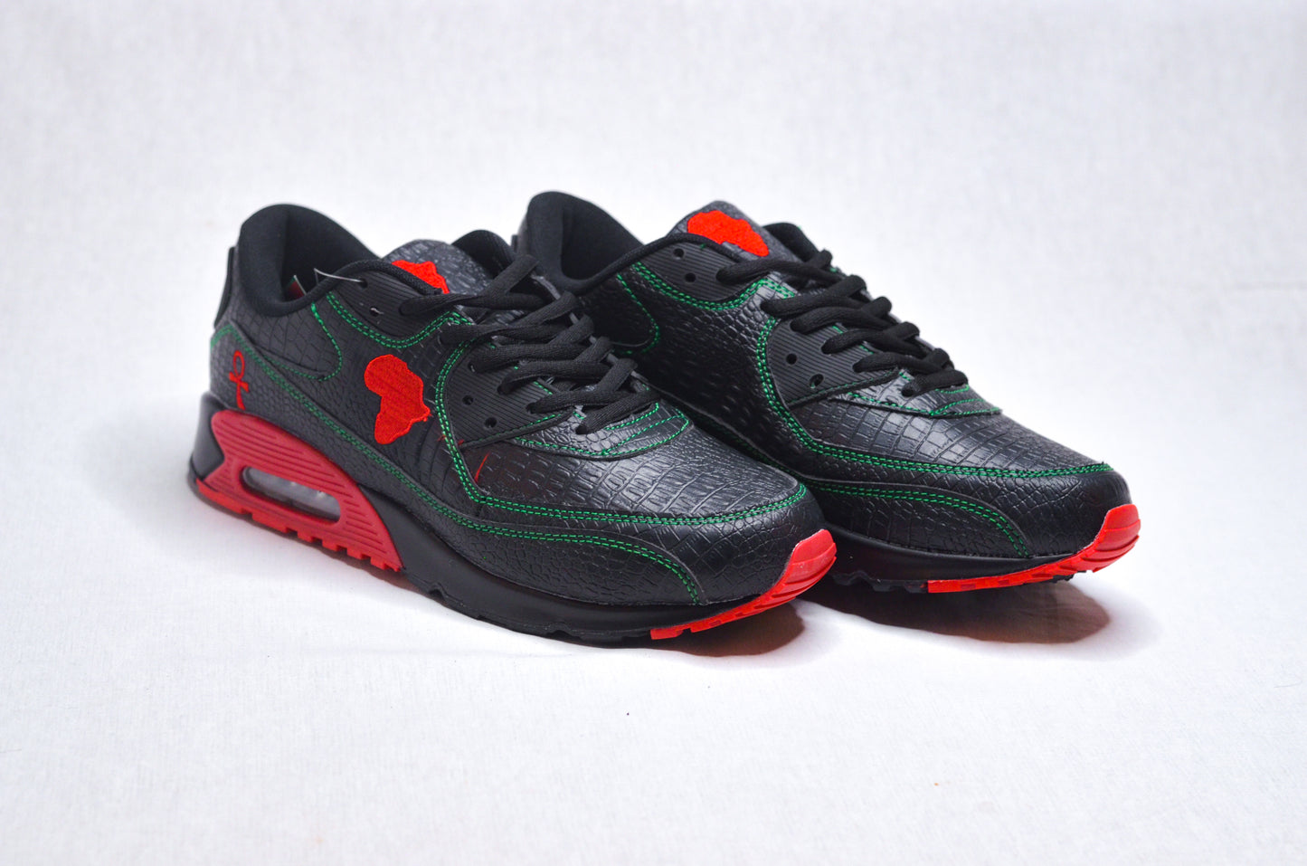 Side profile of MLK Sneakers showing sleek black upper with bold red sole accents.