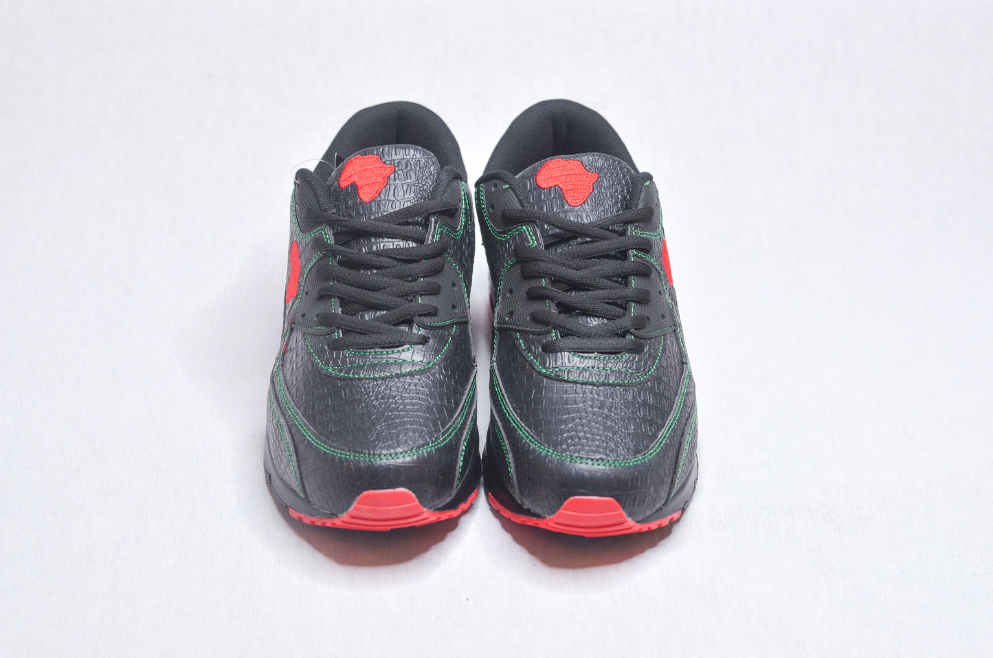 Top-down view of MLK Sneakers displaying black mesh texture with red highlights.