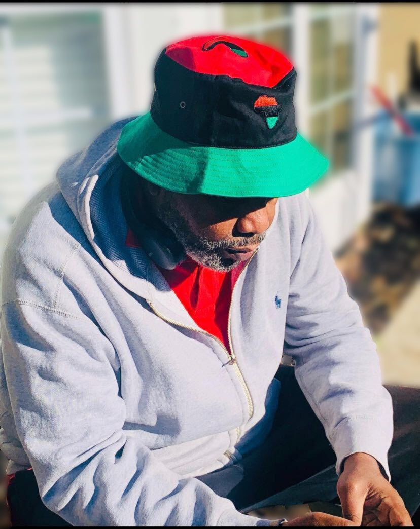 RBG Bucket Hat worn by the shop owner, displaying the African continent motif in Pan-African red, black, and green, representing cultural pride and identity.
