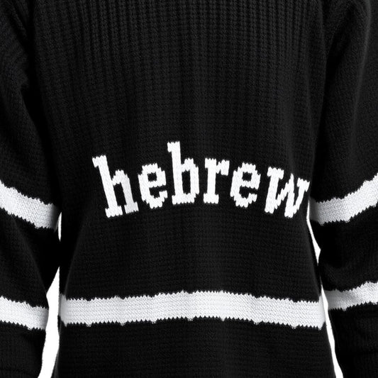 A black wool knitting hoodie with white Hebrew text on the front and white stripes on the sleeves.