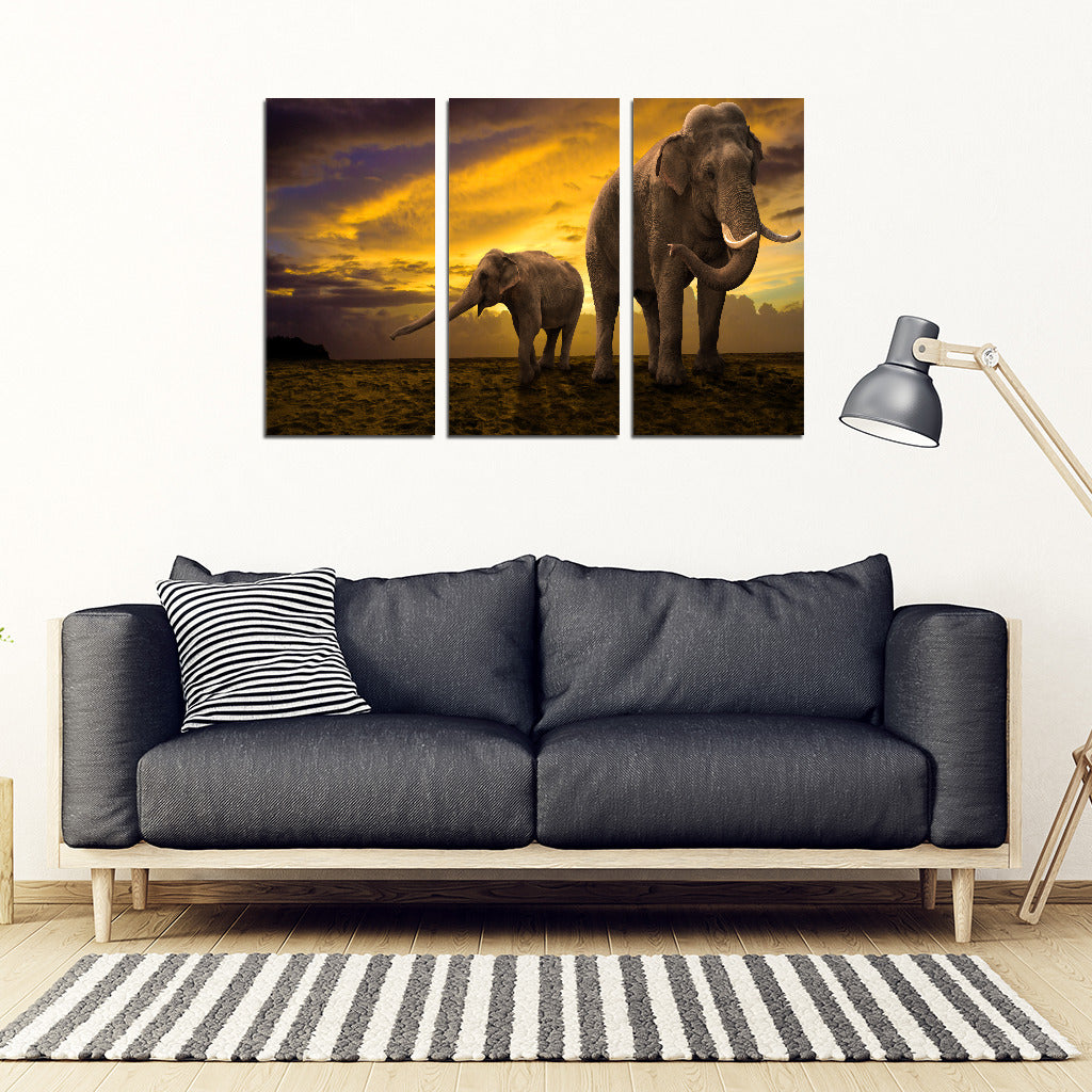 A three-piece canvas art set featuring an elephant in different poses with a dramatic sky background, displayed above a sofa in a living room setting.