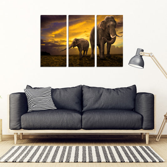 A three-piece canvas art set featuring an elephant in different poses with a dramatic sky background, displayed above a sofa in a living room setting.