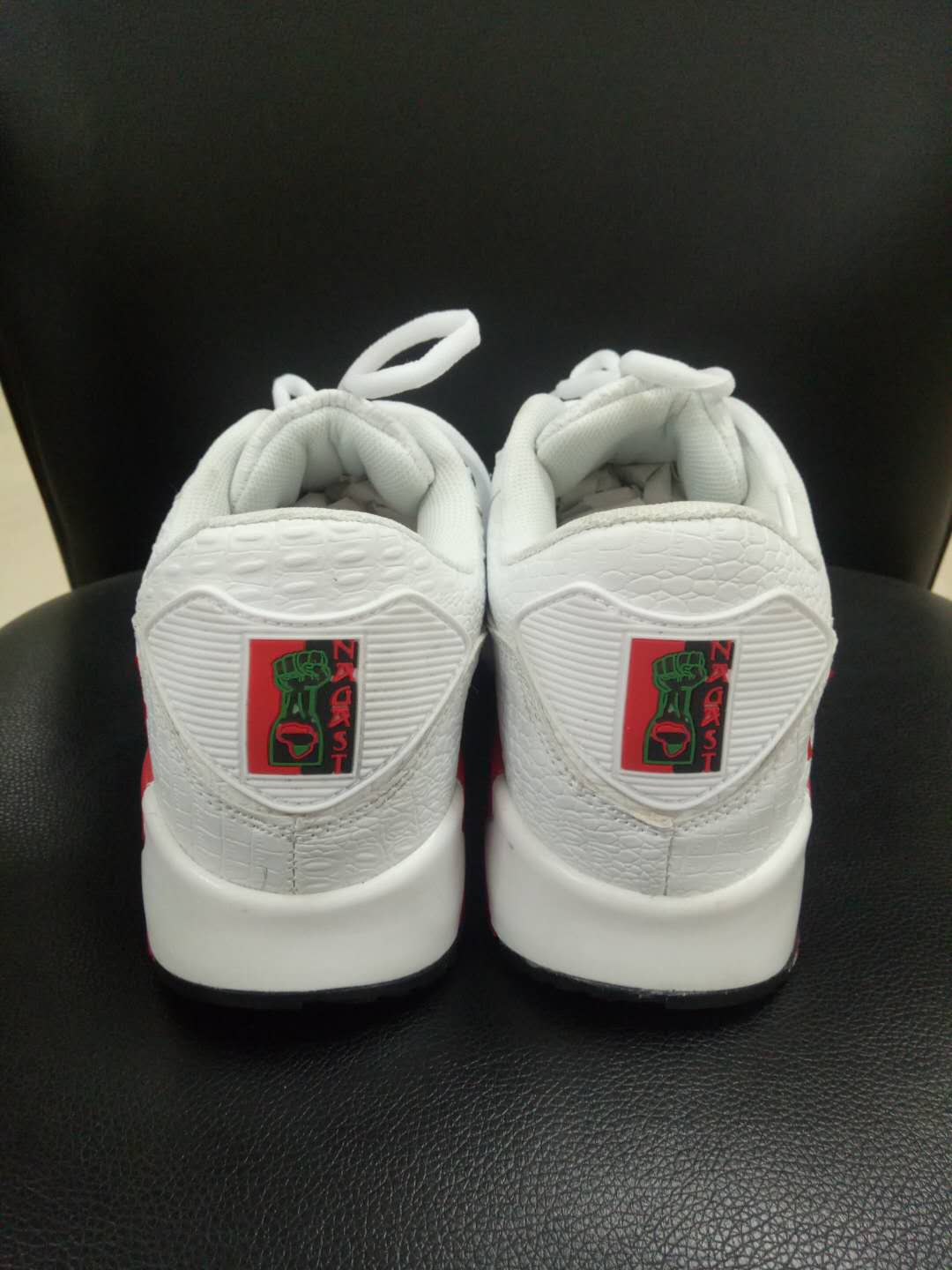 Back view of Marcus Garvey UNIA Star Sneakers against black background with red heel tab.