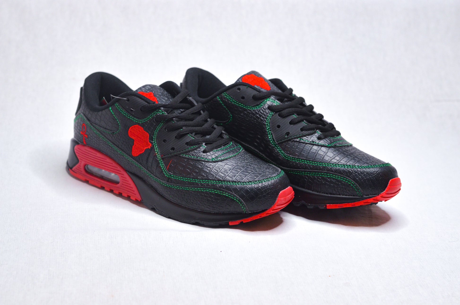 Side profile of MLK Sneakers showing sleek black upper with bold red sole accents.