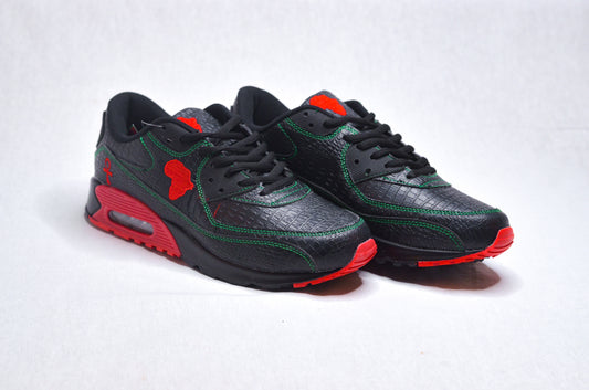 Side profile of MLK Sneakers showing sleek black upper with bold red sole accents.