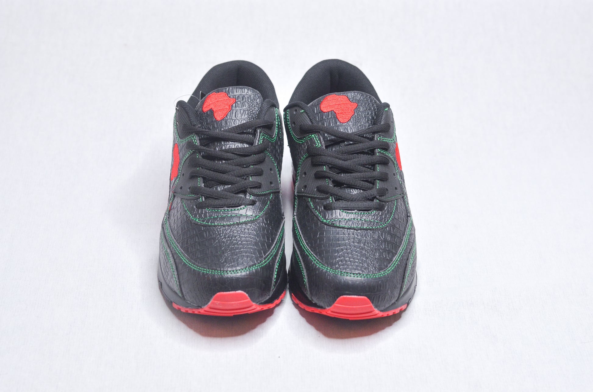 Top-down view of MLK Sneakers displaying black mesh texture with red highlights.